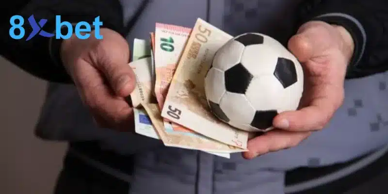 Người chơi cầm quả bóng và tiền cược, nhắc việc quản lý vốn khi chơi thể thao 8xbet